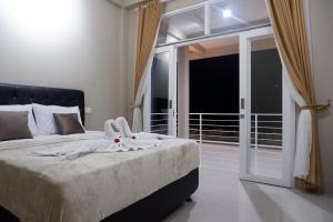 a bedroom with a bed with towels on it at Gunza Bed and Breakfast in Jatiluwih