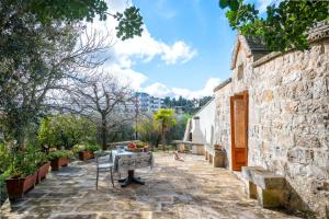 a stone building with a table in the middle of a courtyard at Trullo Nova - Ostuni in Ostuni