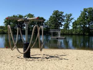 a swing set on a sandy beach next to a lake at Campingplatz am See - zwischen Berlin und Hamburg in Kamern
