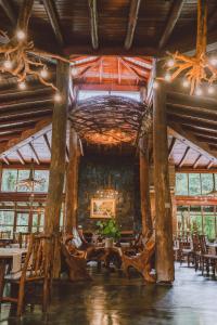 La Aldea De La Selva Lodge في بويرتو إجوازو: غرفة طعام مع طاولات وكراسي في مبنى
