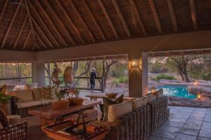 a living room with a table and chairs and a pool at Simbavati River Sands in Timbavati Game Reserve