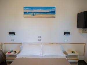ein Schlafzimmer mit einem Bett mit einem Bild an der Wand in der Unterkunft Hotel Pari in Misano Adriatico