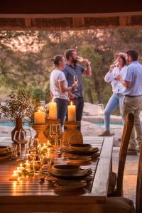 a group of people standing around a table with candles at Simbavati River Sands in Timbavati Game Reserve