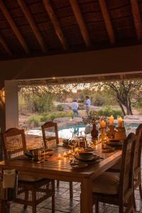 a wooden table with chairs and a table with candles at Simbavati River Sands in Timbavati Game Reserve