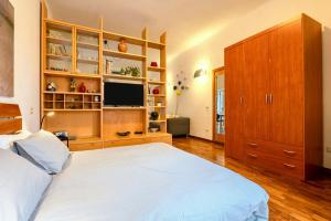 a bedroom with a large white bed and a television at Casa Le Margherite 1 in Grottaglie