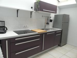 una cucina con lavandino e frigorifero di GÎTE L'ISABEY ETRETAT a Étretat