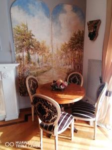 una sala da pranzo con tavolo, sedie e un quadro di B&B Buon Cammino Tuscia Viterbo a Viterbo