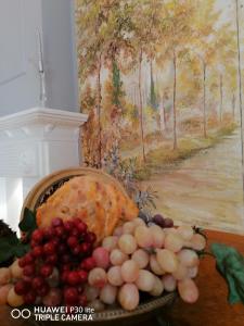 un cesto di frutta su un tavolo accanto a un quadro di B&B Buon Cammino Tuscia Viterbo a Viterbo