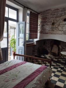 una camera da letto con un letto e un muro di pietra di Fasolas square studio 15m2 is located 30 stairs up from the main road and it is in the old market fasolas and next to the museums a Philotium