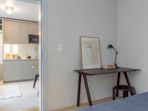 a bedroom with a desk with a picture and a kitchen at UNITY Malmö in Malmö
