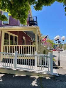 a house with a white fence and a porch at Central House Inn in Bar Harbor