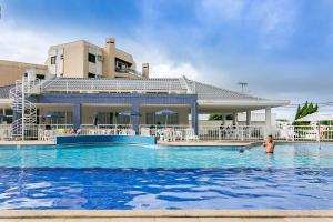 una piscina en un complejo con un perro en el agua en 100m da Praia | Churrasqueira na Sacada #IA23, en Florianópolis