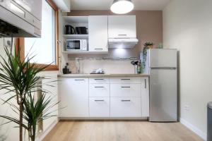  La cuisine est équipée de placards blancs et d'un réfrigérateur. dans l'établissement Le Cocon des Jacobins - Rennes Centre, à Rennes