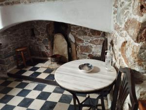 un tavolo in una stanza con un muro in pietra di Fasolas square studio 15m2 is located 30 stairs up from the main road and it is in the old market fasolas and next to the museums a Philotium