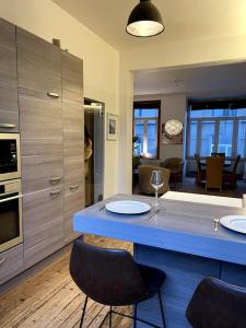 uma cozinha com um balcão azul com duas cadeiras em Ostend Zen em Oostende