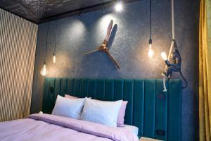 a bedroom with a bed with a green headboard and two propellers at Quiboo #4 in Braşov