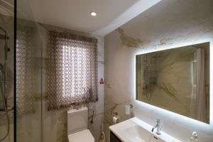 a bathroom with a toilet and a sink and a mirror at Modern 3 bedroom Apartment in Luqa (Sleeps 6) in Luqa