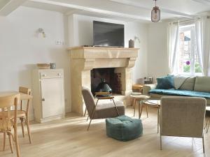 a living room with a couch and a fireplace at La Maison Harmony in Beuvron-en-Auge