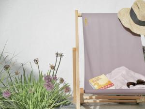 a book sitting on a bed next to some flowers at La Maison Harmony in Beuvron-en-Auge +14 photos