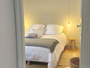 奥格地区伯夫龙La Maison Harmony的卧室里有一张床，床单和枕头都是白色的