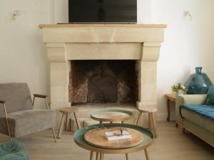 a living room with a fireplace with a tv on top at La Maison Harmony in Beuvron-en-Auge