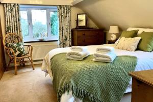 a bedroom with a bed with towels on it at Little Acre, a spacious hidden gem with hot tub in Kington