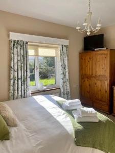 sypialnia z dużym białym łóżkiem i oknem w obiekcie Little Acre, a spacious hidden gem with hot tub w mieście Kington