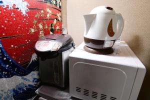 uma máquina de café sentada em cima de um micro-ondas em Jing House akihabara Ryokan - Vacation STAY 11566v em Tóquio