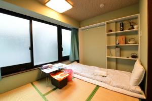 um quarto com uma cama e uma grande janela em Jing House akihabara Ryokan - Vacation STAY 11566v em Tóquio
