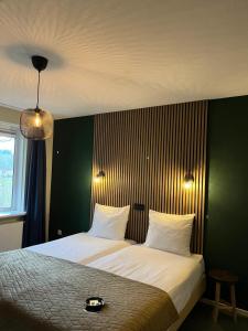 a bedroom with a large white bed with a green wall at Hotel De Barones in Dalfsen