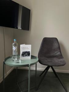 a chair and a glass table with a bottle on it at Hotel De Barones in Dalfsen