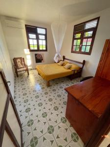 1 dormitorio con cama, mesa y ventanas en Anacaona by UTA HOUSE, en Sainte-Anne