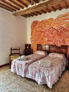 a bedroom with two beds and a large wooden headboard at La casa nel Castello in Canneto