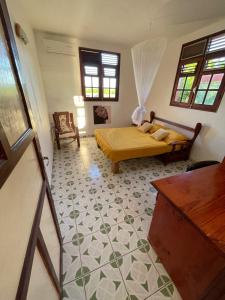 1 dormitorio con 1 cama con edredón amarillo en Anacaona by UTA HOUSE, en Sainte-Anne