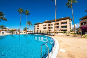 een zwembad met palmbomen voor een gebouw bij Peaceful Paraiso in Playa Paraiso