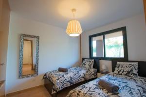 een slaapkamer met een bed, een spiegel en een raam bij Peaceful Paraiso in Playa Paraiso +16 foto's