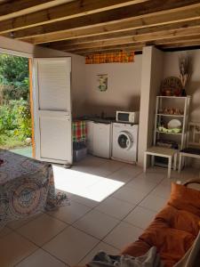 a living room with a kitchen and a microwave at Un petit coin de Paradis in Deshaies