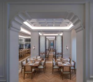 The Chedi Katara Hotel & Resort في الدوحة: تقديم غرفة طعام مع طاولات وكراسي