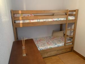 two bunk beds in a room with a table at Petit cocon entre lac, golf et montagne, proche d'Annecy in Giez