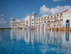 un gran edificio blanco con agua delante en The Chedi Katara Hotel & Resort, en Doha