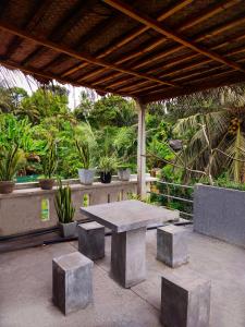希卡杜瓦的住宿－Mandara Rest，混凝土野餐桌和一些植物和树木