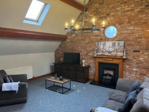 a living room with two couches and a fireplace at Pillory House Loft Apartment in Nantwich