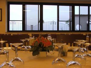 uma sala de jantar com mesas, cadeiras e janelas em Hotel Panorama Del Golfo em Manfredonia