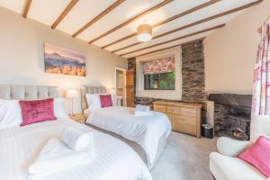 a bedroom with two beds and a fireplace at Tower Cottage Far Sawrey Windermere in Far Sawrey