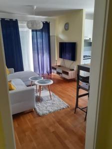 sala de estar con sofá blanco y mesa en Apartman Arena-Velesajam VITO, en Zagreb