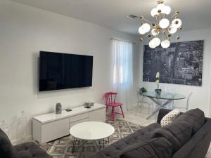 a living room with a couch and a tv at Xanadu Villas - 3 Bedroom House or 2 Bedroom Apartment in Miami