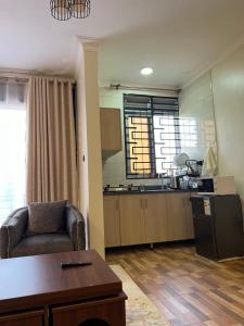 a living room with a couch and a kitchen at Bibi Homes in Kampala