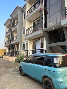 a blue van parked in front of a building at Bibi Homes in Kampala