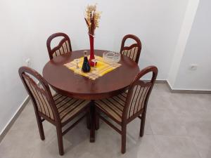 una mesa de madera con sillas y un jarrón con flores. en Apartment Angel, en Kotor