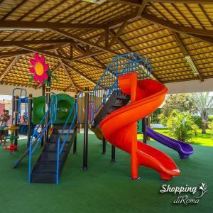 un parque infantil con un tobogán rojo y un tobogán en Caldas Novas - Lacqua diRoma - com 1 dia de acesso ao Acqua Park Vulcao e roupas de cama - ate 4 pessoas, en Caldas Novas